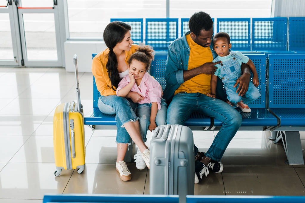 stock photo cheerful african american family travel bags kids sitting airport waiting